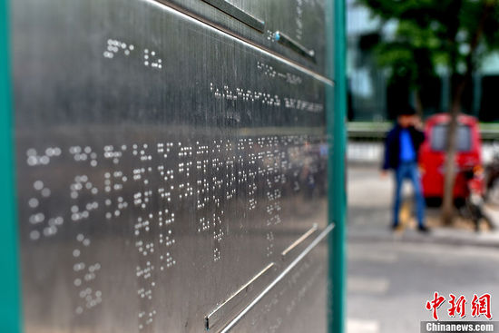 5月25日，北京市西直門公交車站臺(tái)上，一座用盲文“書寫”站點(diǎn)的不銹鋼盲文公交站牌悄然建成。在站牌下方圍繞站牌鋪設(shè)的盲人步道與站牌的結(jié)合方便了盲人的乘車出行。中新網(wǎng)記者